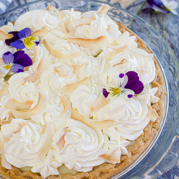 angle of coconut cream pie on blue table