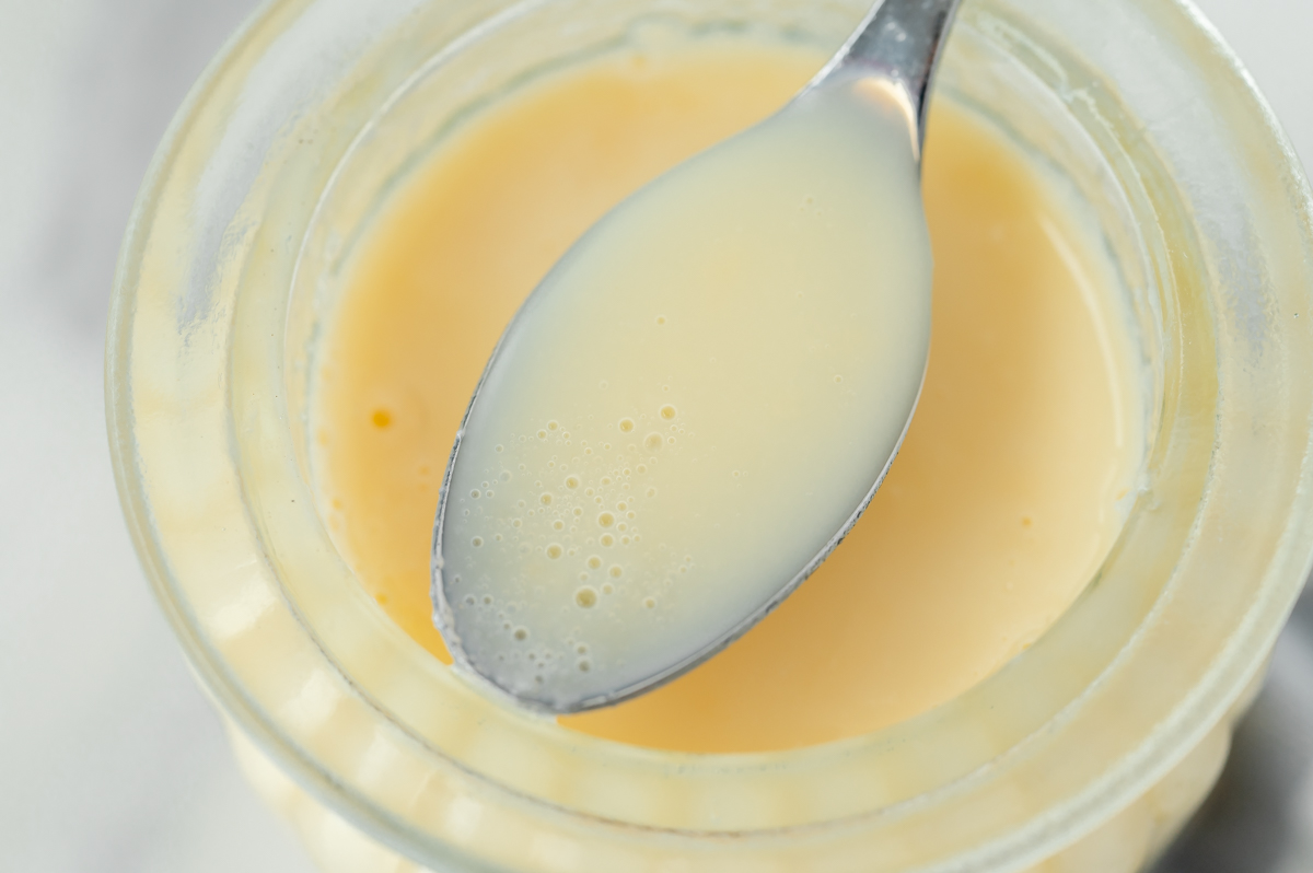 close up angled shot of spoon of sweetened condensed milk