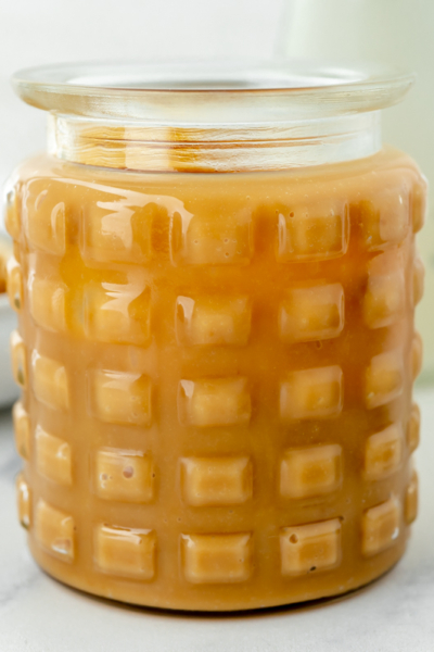 angled shot of jar of sweetened condensed milk caramel