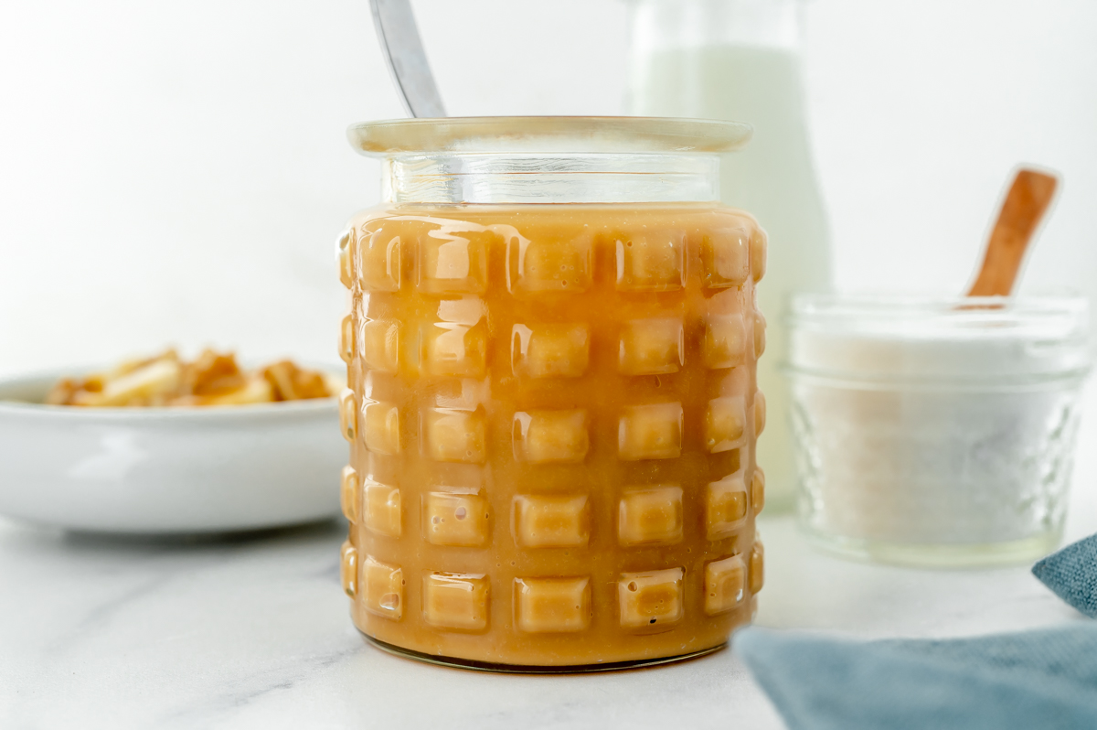 straight on shot of spoon in jar of caramel