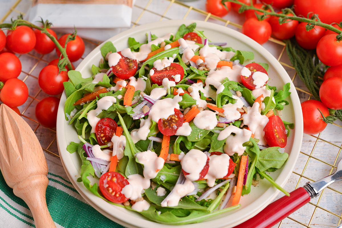 angled shot of salad topped with creamy tomato salad dressing