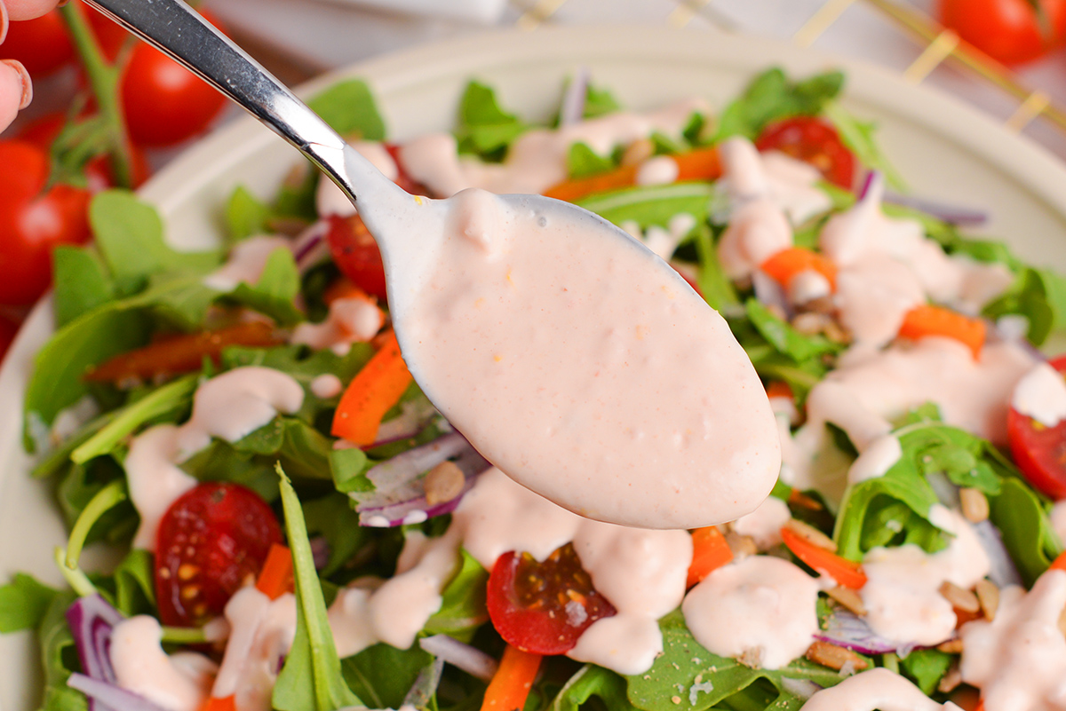 angled shot of creamy tomato salad dressing on spoon