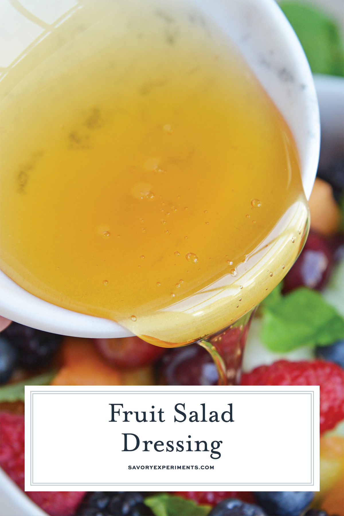 close up of pouring dressing for fruit salad with text overlay