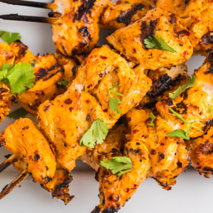 close up overhead shot of harissa chicken skewers on white tray