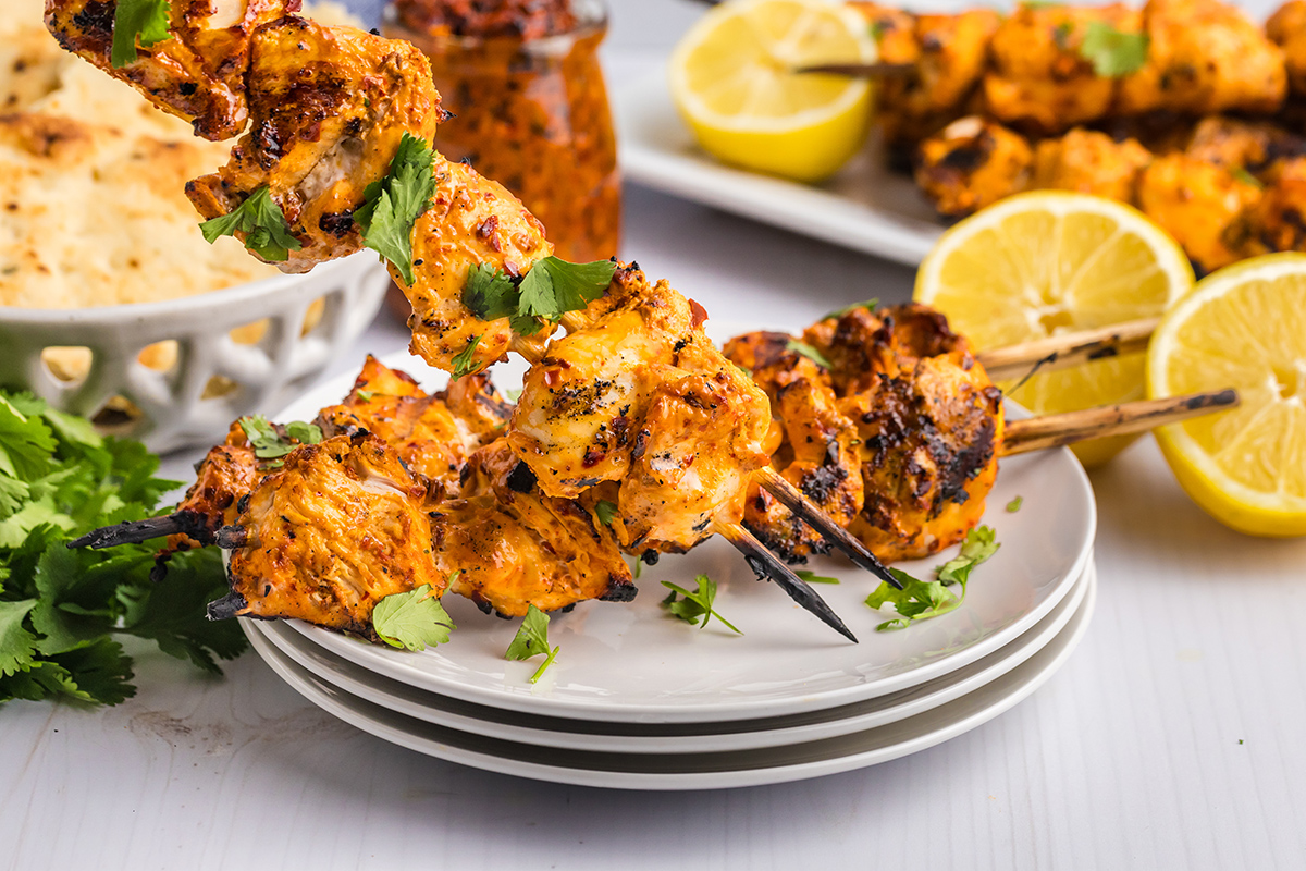 angled shot of harissa chicken kabobs on plate