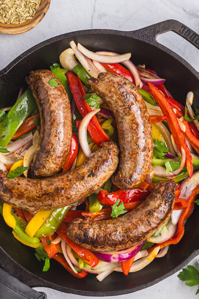 overhead shot of homemade italian sausage in pan with peppers and onions