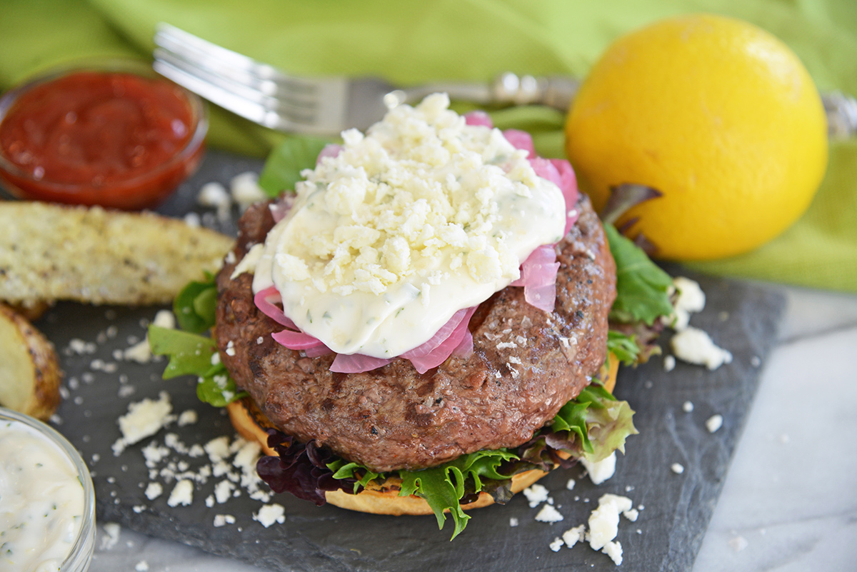serving greek burgers with lemon and potato wedges