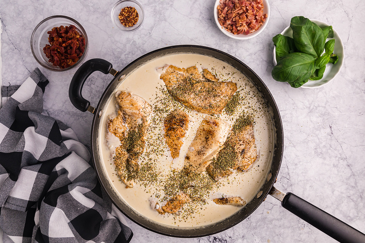 Chicken cooking in creamy sauce in pan