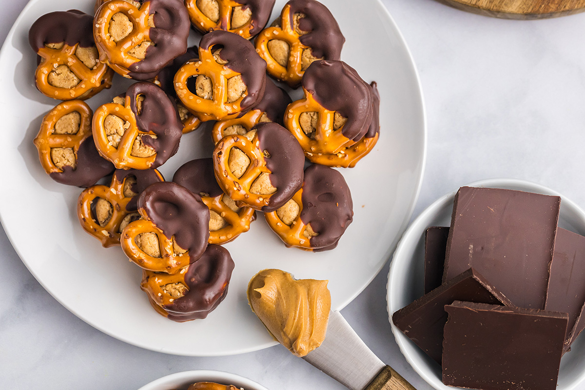 overhead shot of plate of peanut butter pretzel bites with knife of peanut butter