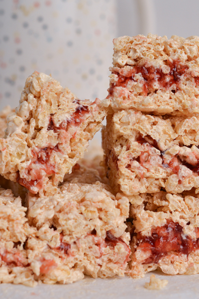 peanut butter and jelly rice krispie treats stacked in a pile