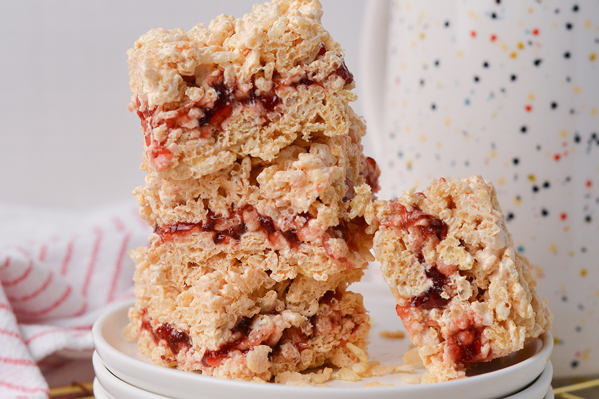 close up shot of stack of peanut butter and jelly rice krispie treats on a stack of plates