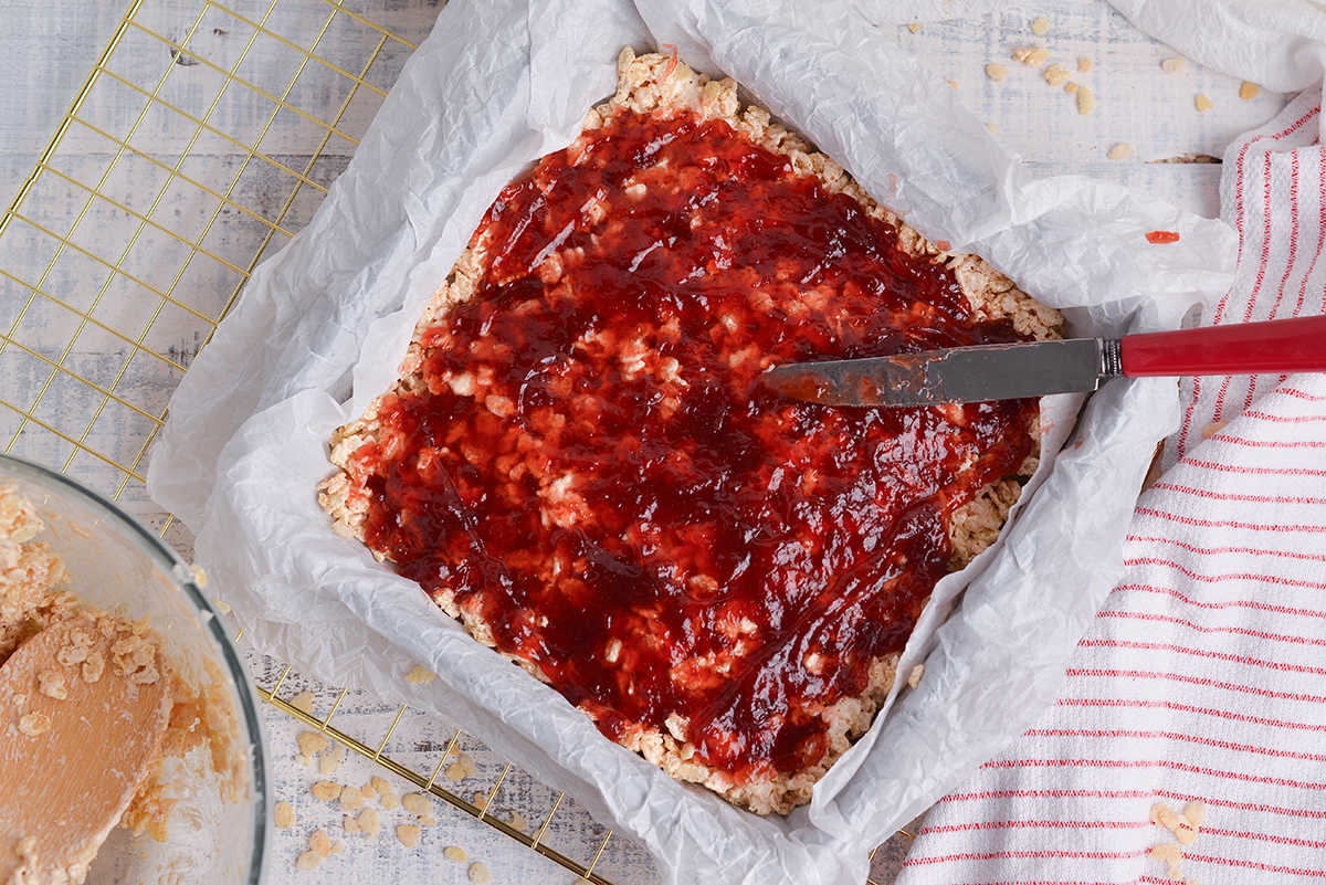 jelly spread over rice krispie mixture in pan