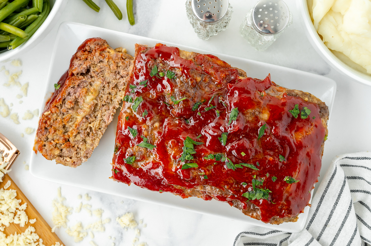 overhead shot of stuffed meatloaf on platter with slice cut off