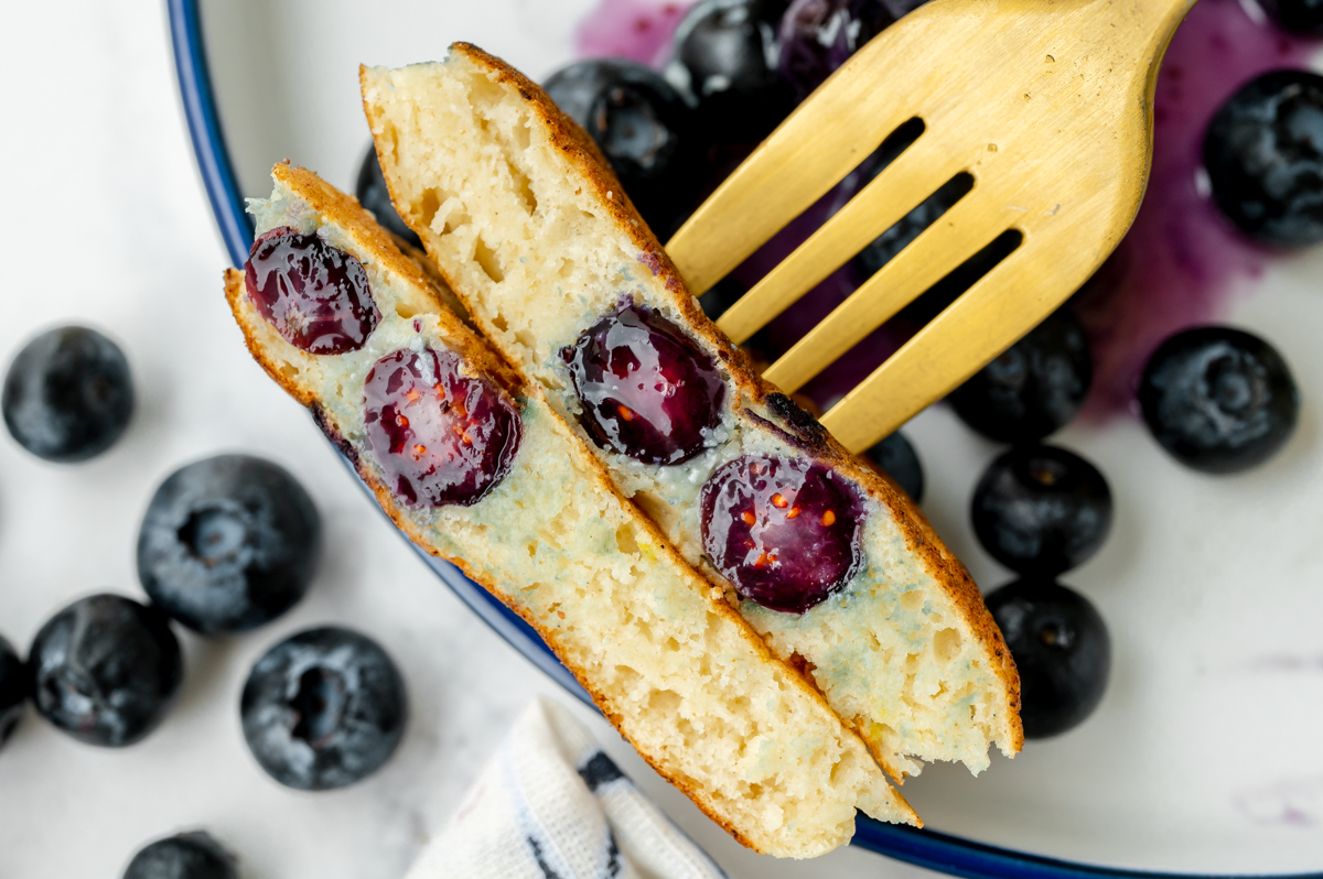 overhead shot of bite of blueberry pancakes on fork