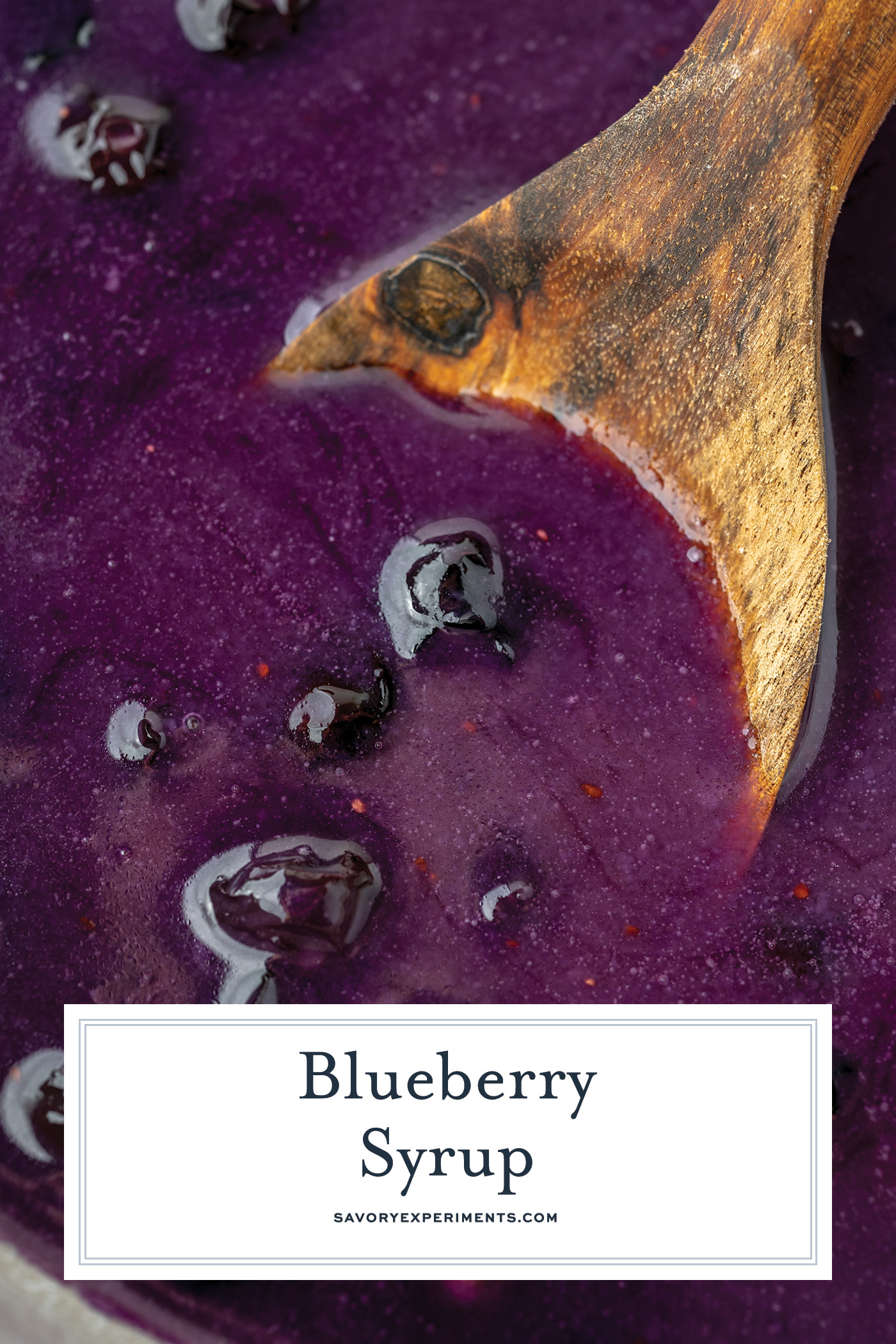 overhead shot of wooden spoon in pan of homemade blueberry syrup with text overlay