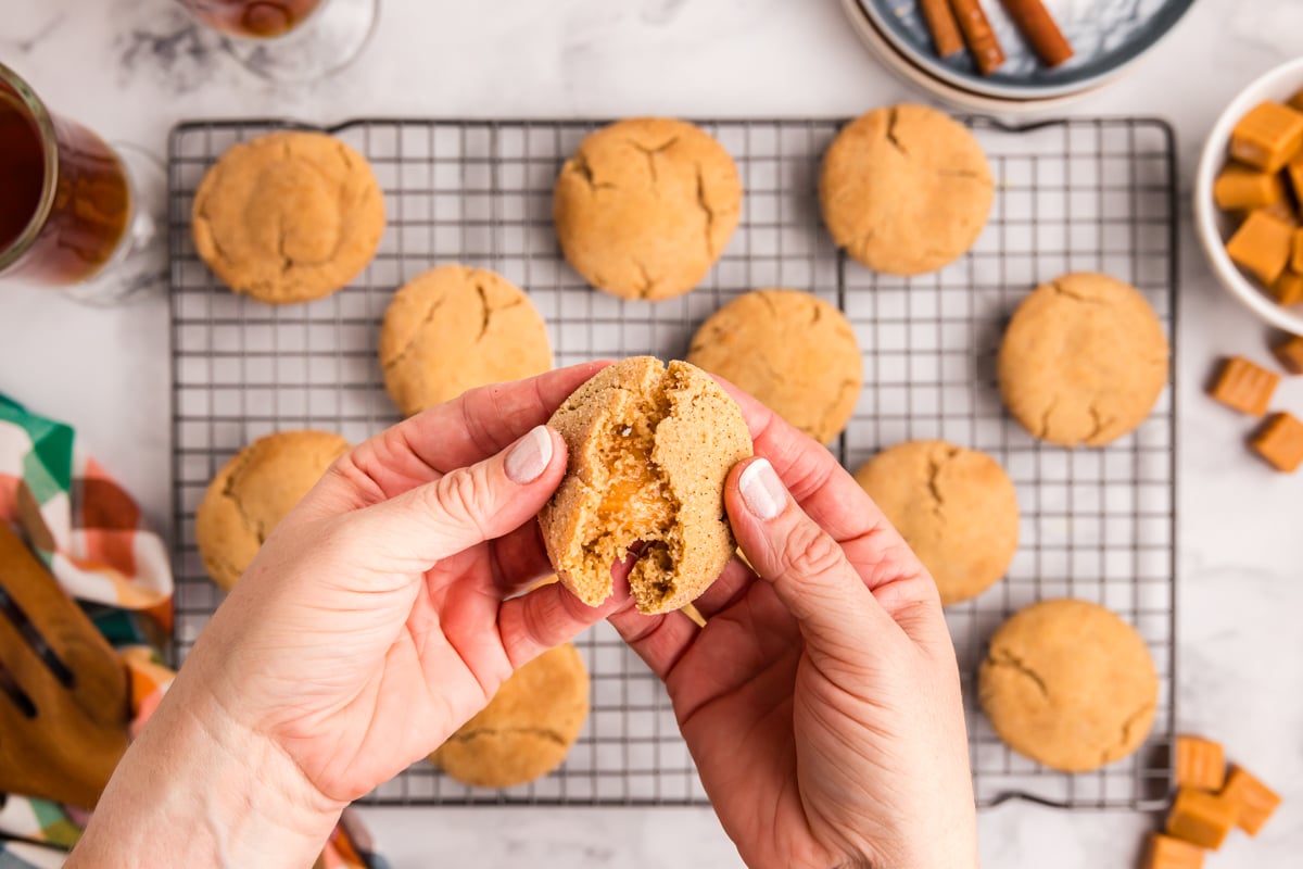 hand breaking caramel apple cookie in half