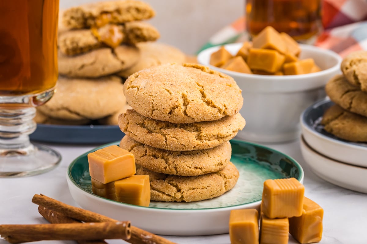 stack of caramel apple cookies on plate with caramel squares