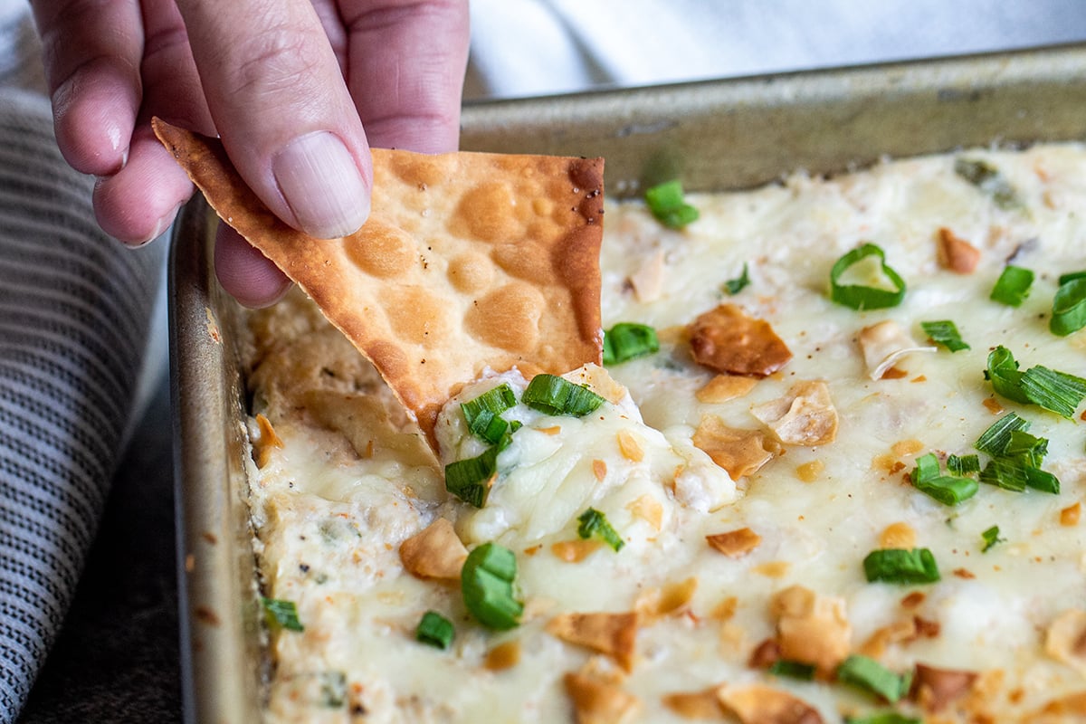 chip dipping into cheese dip