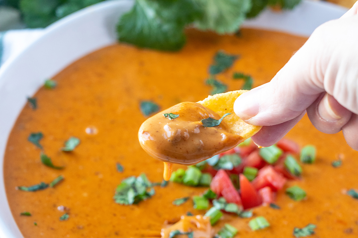 slow cooker chili cheese dip on a corn chip