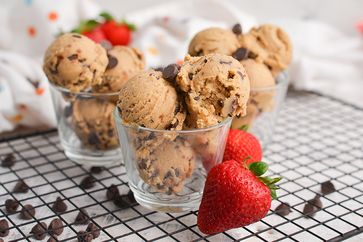 head-on image of chocolate chip cookie dough bowls surrounded by fresh strawberries