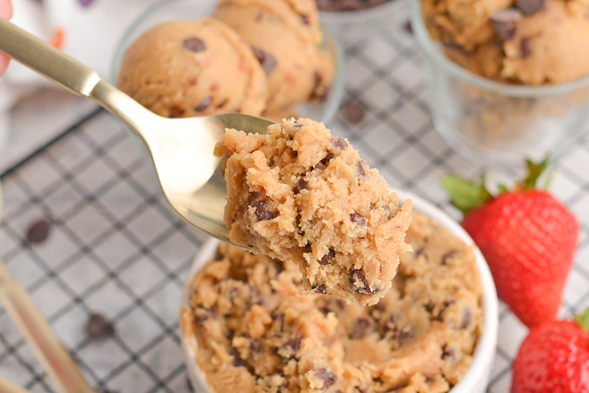 close up of a gold spoon with edible chocolate chip cookie dough on it