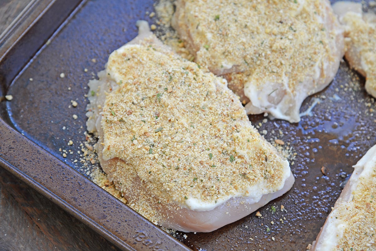 breadcrumbs and mayo on raw chicken breast