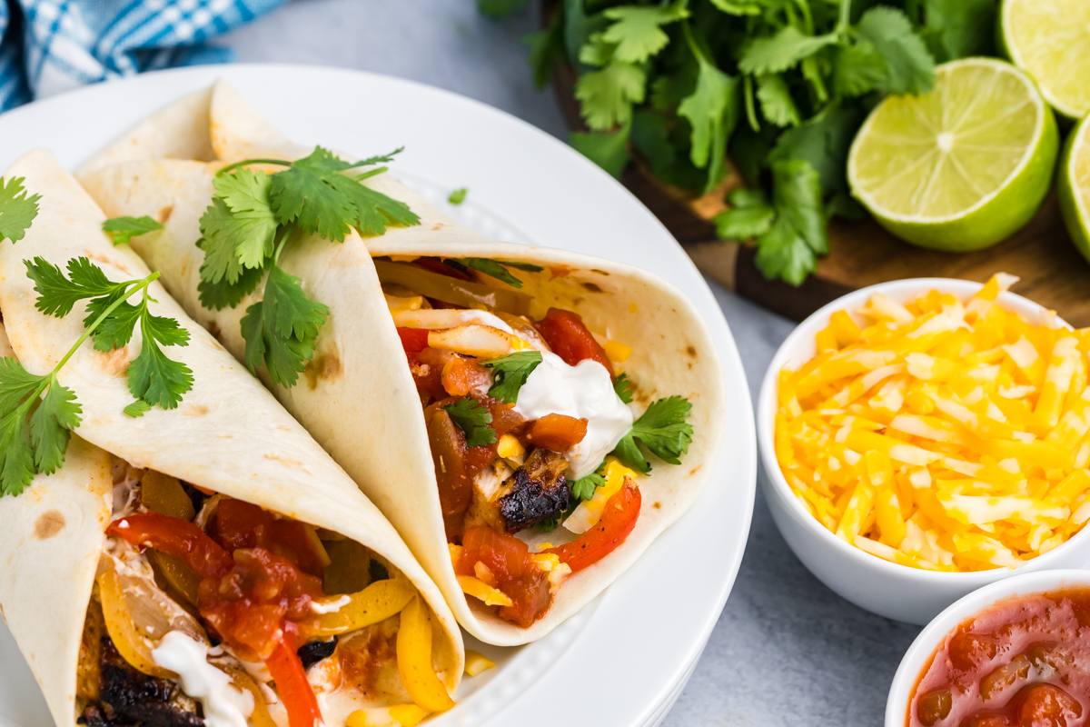 angled shot of two grilled chicken fajitas on plates