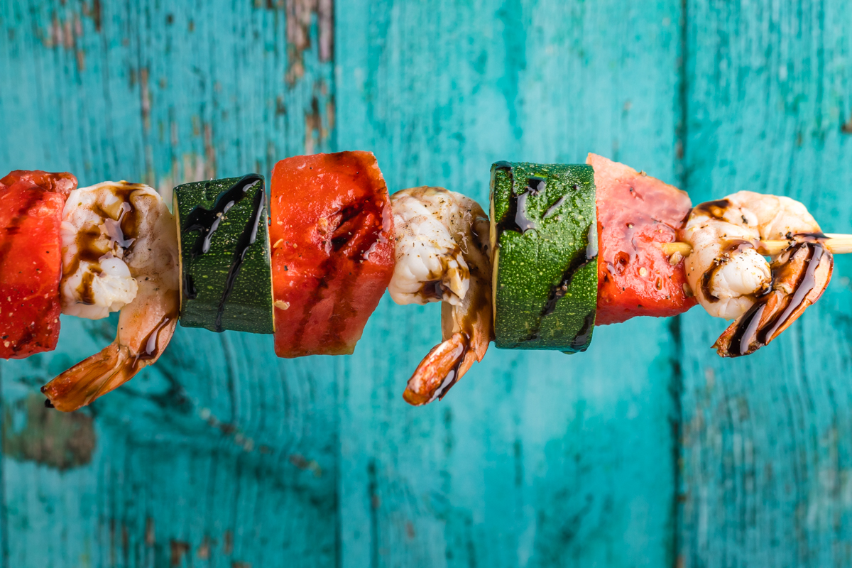 grilled watermelon shrimp kabob over blue background