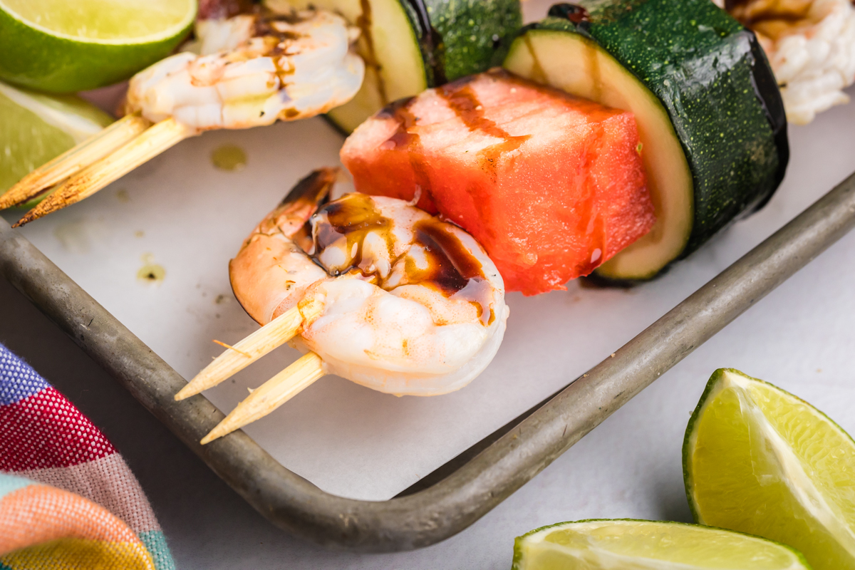 angled shot of grilled watermelon shrimp kabobs on sheet pan