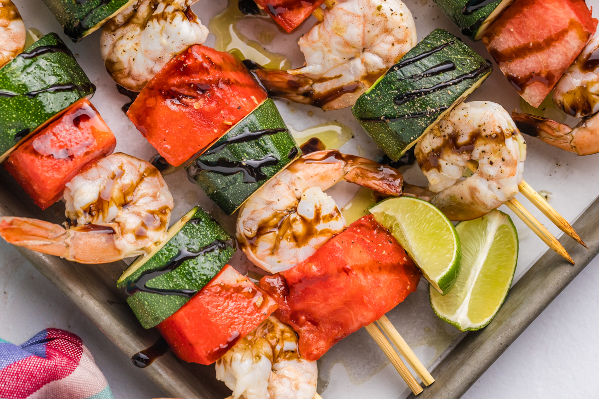 close up overhead shot of watermelon shrimp kabobs on sheet pan