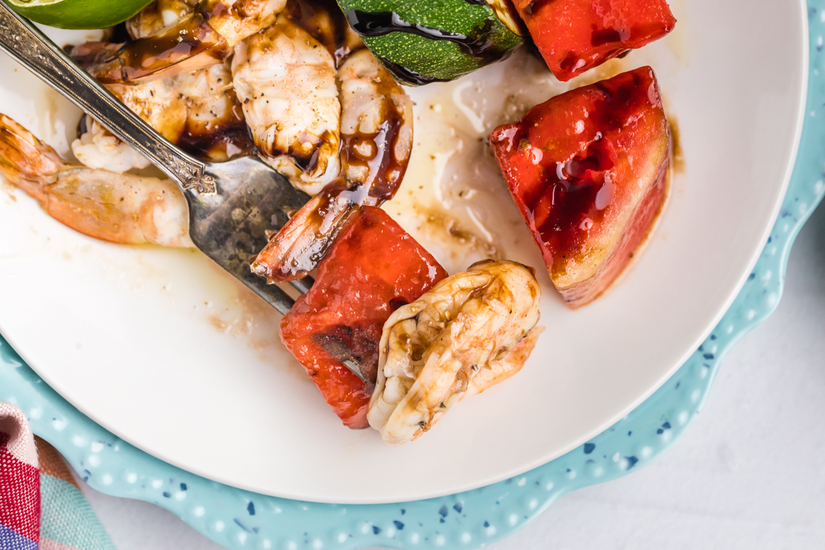 close up overhead shot of bite of grilled watermelon and shrimp on fork