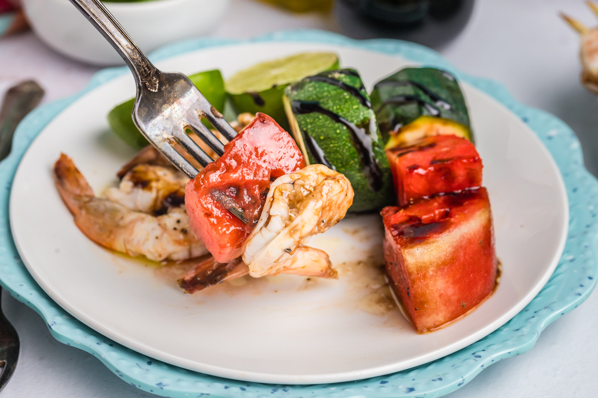 angled shot of bite of grilled watermelon and shrimp on fork