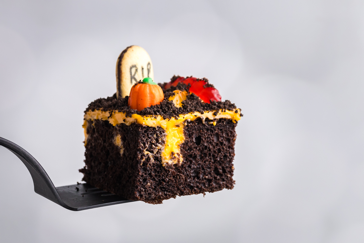 straight on shot of halloween poke cake slice on spatula