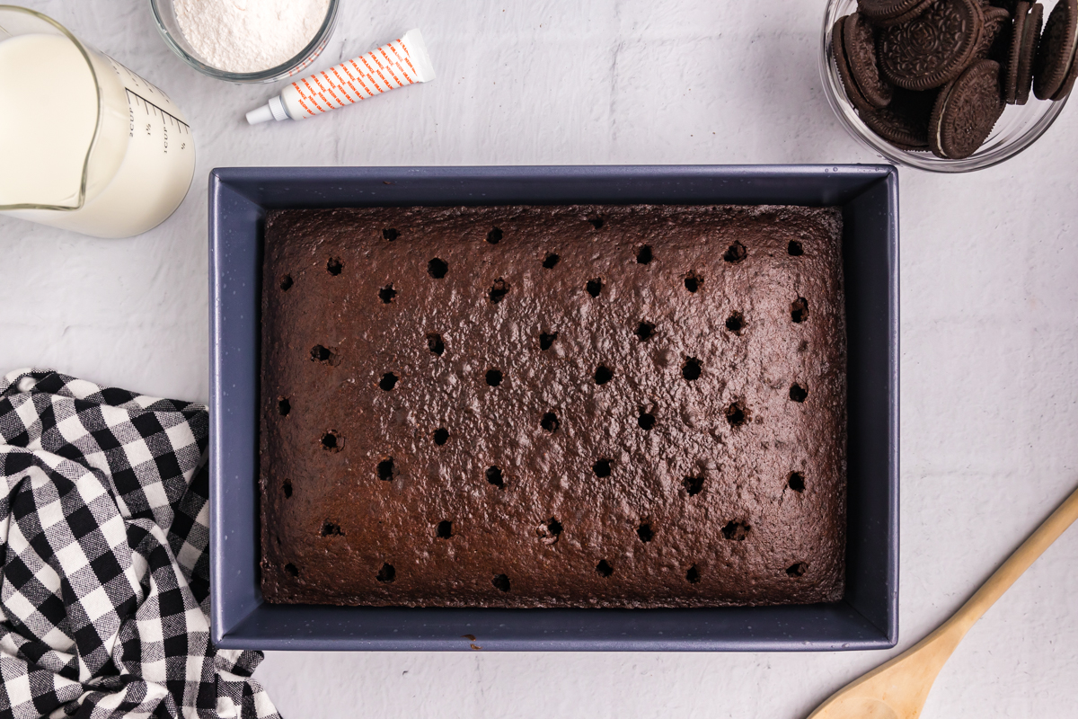 overhead shot of holes poked into chocolate cake