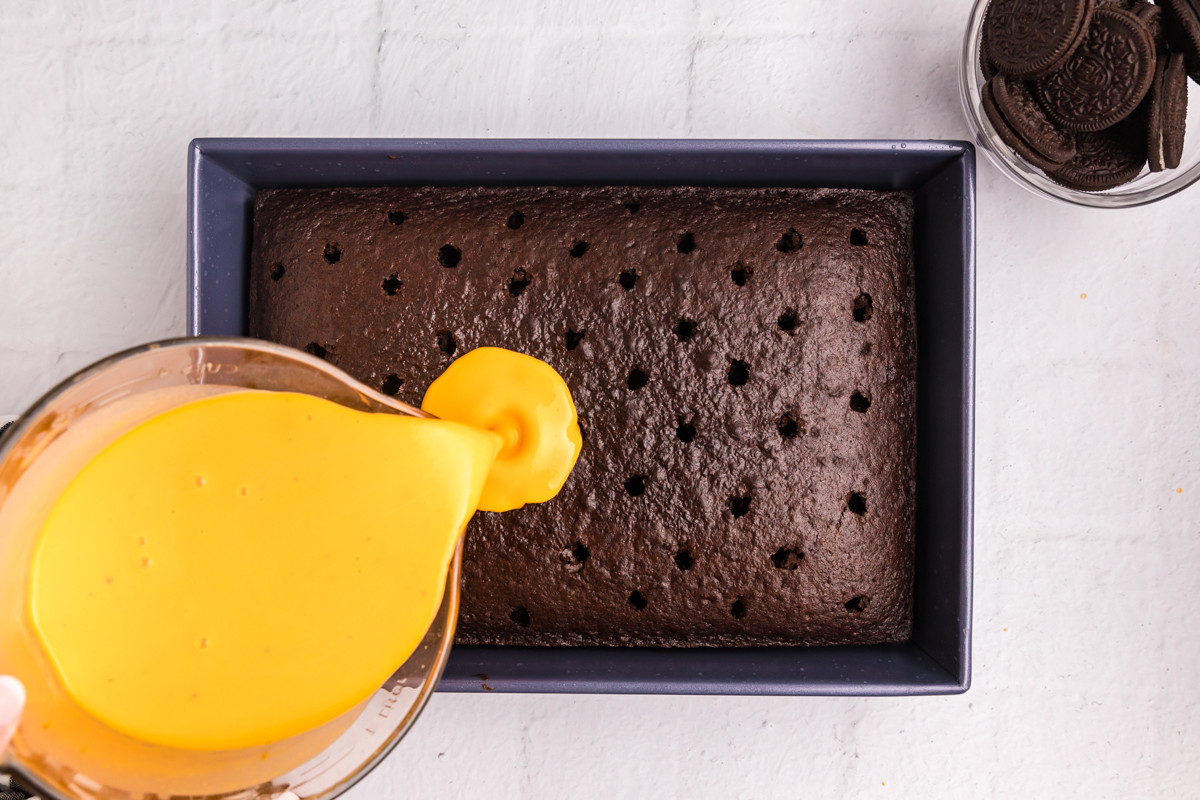 overhead shot of orange pudding poured over chocolate cake