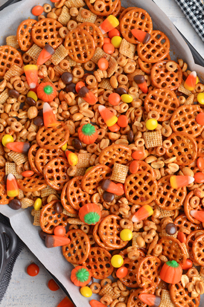 overhead of snack mix on a rimmed baking sheet with parchment paper