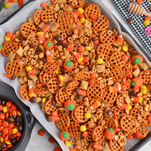 overhead of snack mix on a rimmed baking sheet with parchment paper