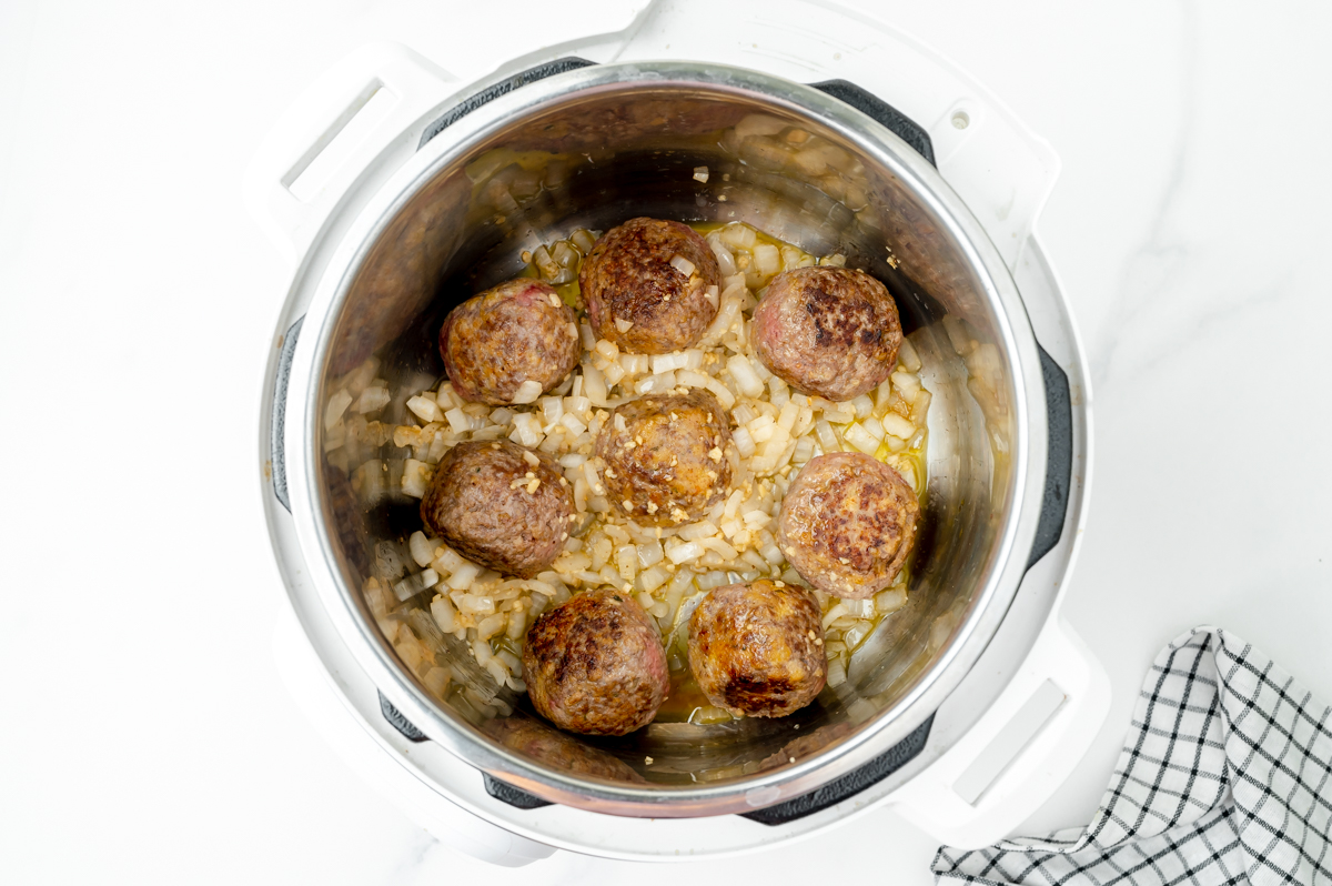 overhead shot of meatballs and onion cooking in Instant Pot