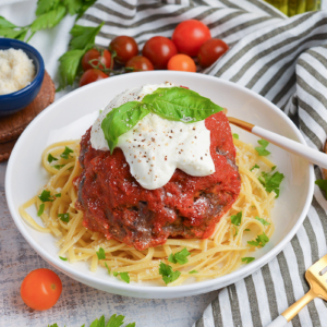 angled shot of lavo one pound meatball over pasta in bowl