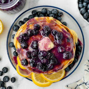 overhead shot of stack of pancakes topped with blueberry syrup