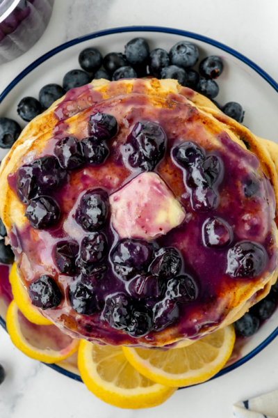 overhead shot of stack of pancakes topped with blueberry syrup