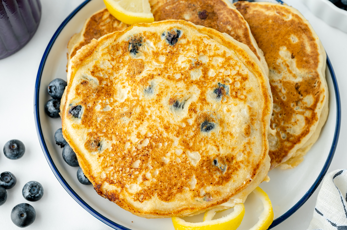 close up shot of plate of three lemon ricotta pancakes