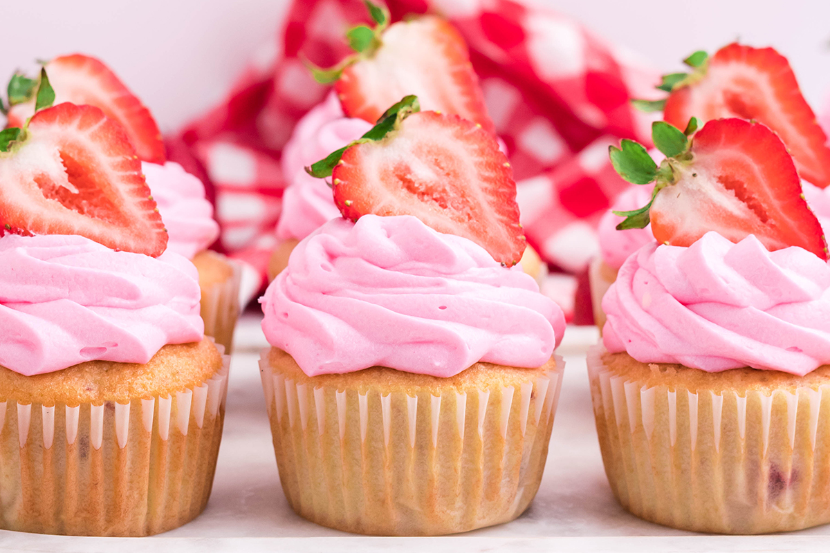 straight on shot of three lemon strawberry cupcakes