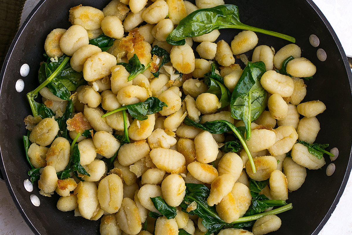 gnocchi and spinach cooking in pan