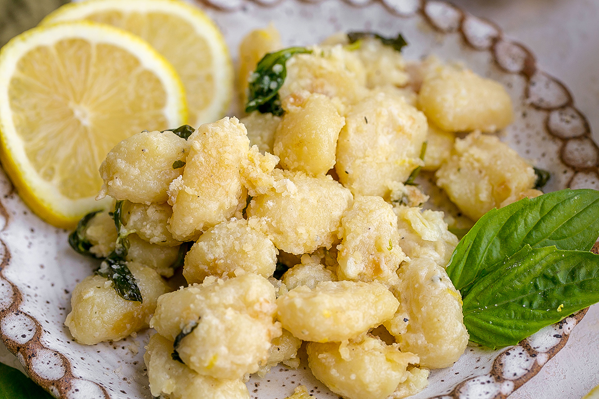 close up angled shot of creamy gnocchi on plate