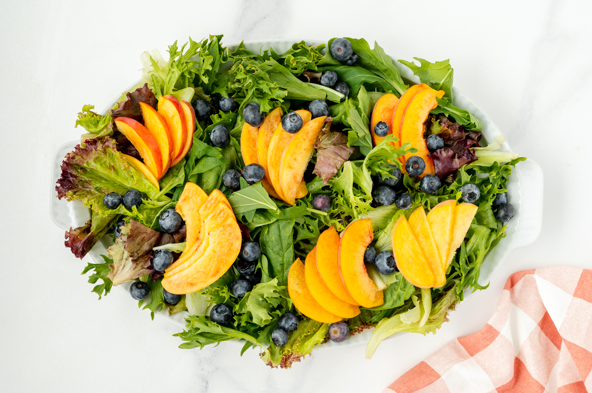 peaches and blueberries on spring lettuce