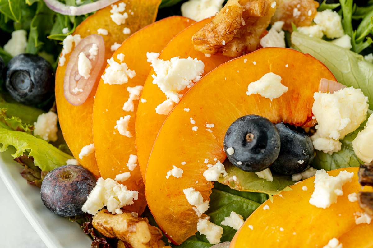 sliced peaches and blueberries on salad