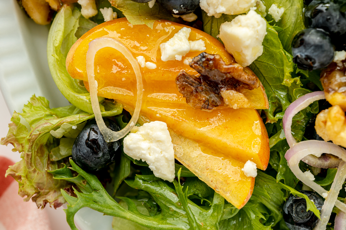 close up overhead shot of sliced peaches on salad