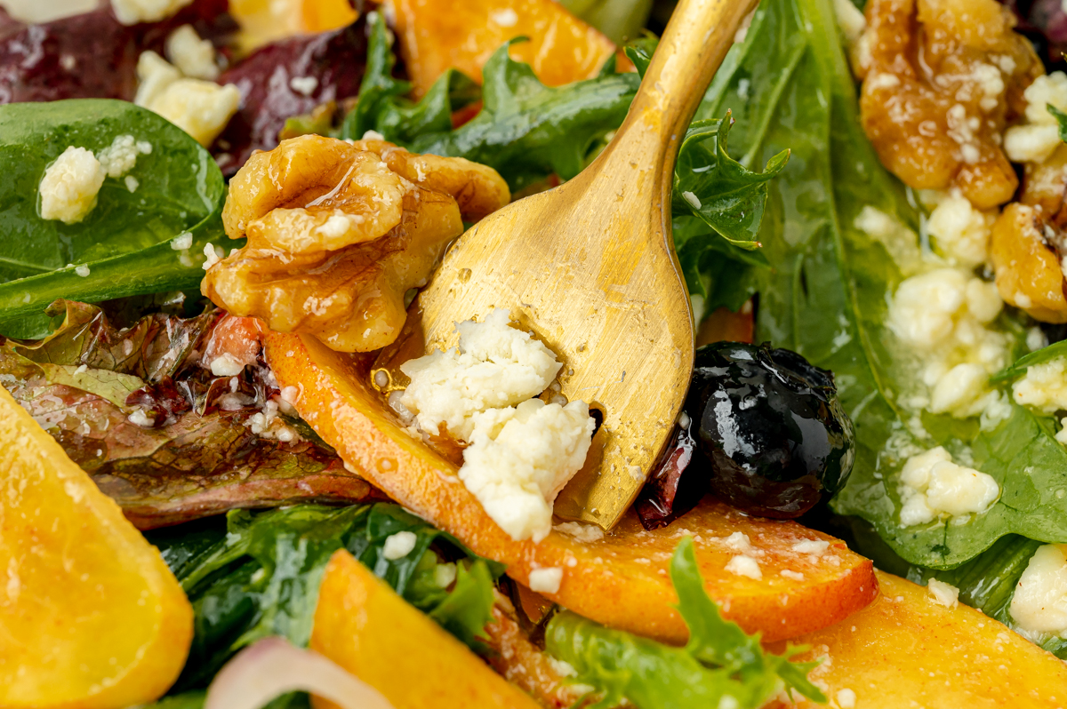 close up of fork getting bite of peach salad