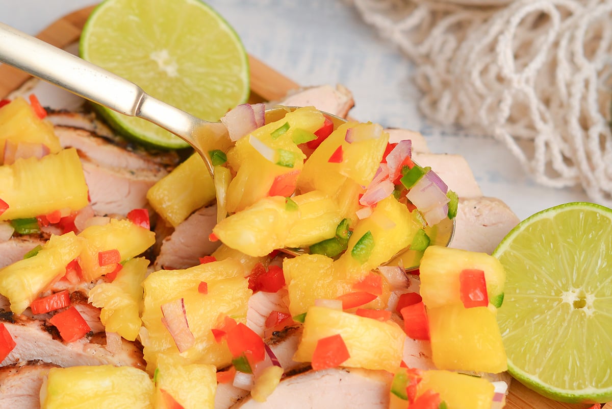 close up shot of spoon adding salsa to chicken